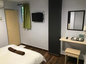 Cette chambre comprend un lit, un miroir et une table. dans l'établissement Hotel dan Restoran Seri Kangsar, à Kuala Kangsar