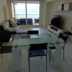 uma sala de estar com uma mesa de vidro e cadeiras em Passeig del Mar, 2 em Palamós