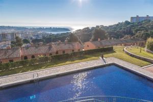 a large swimming pool with a view of a city at Casa pilar in S'Agaro