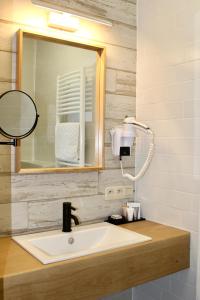a bathroom with a sink and a mirror at B&B Villa Verde in De Haan