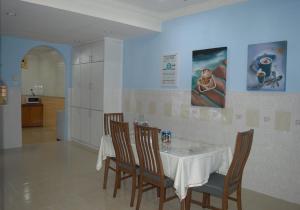 a dining room with a white table and chairs at Gallery@7Homestay in Shah Alam