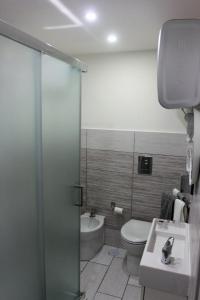 een badkamer met een douche, een toilet en een wastafel bij Nel Cuore di Napoli in Napels