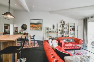 ein Wohnzimmer mit einem roten Sofa und einem Tisch in der Unterkunft Escapade en Provence in LʼIsle-sur-la-Sorgue + 7 Fotos