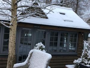 a house with snow on top of it at Truffle Lodge in Lindfield