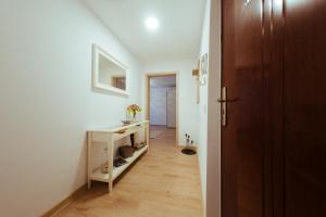 a hallway with a white room with a desk and a door at Urban Living Apartment in Timişoara