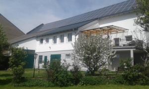uma casa branca com painéis solares em Mühlbachhof em Berg
