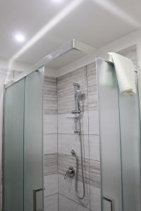 une douche avec une porte en verre dans une salle de bain dans l'établissement Nel Cuore di Napoli, à Naples
