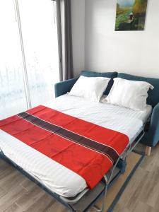 Una cama con una manta roja y blanca. en villa alex, en Toulouse