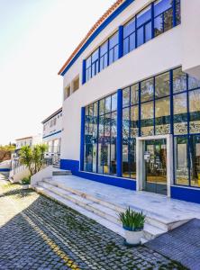 biały budynek z niebieskimi oknami i drzwiami w obiekcie Termas da Sulfurea w mieście Cabeço de Vide