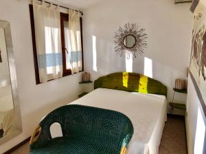a bedroom with a bed with a green chair at Villa Bianca in Capitana