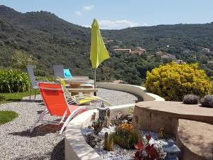 patio con sedie, tavolo e ombrellone giallo di Résidence U MELU GRAND T3 ROUGE en rez de jardin a Tiuccia