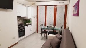 a living room with a couch and a table in a kitchen at Casa Excalibur in Pisa