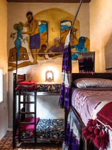 una camera con un letto e un dipinto sul muro di The Chill Art Hostel a Essaouira