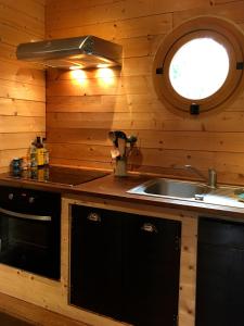 - une cuisine avec évier et une fenêtre dans une cabine dans l'établissement Ma Cabane à Sarlat, à Sarlat-la-Canéda