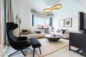 a living room with a black chair and a couch at Westminster Burj Residences in Dubai