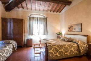 sypialnia z 2 łóżkami, stołem i oknem w obiekcie Antica Pieve B&B w mieście Tavarnelle Val di Pesa