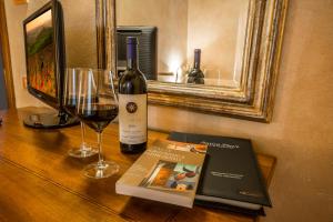 - une bouteille de vin, un livre et un verre de vin dans l'établissement Antica Pieve B&B, à Tavarnelle in Val di Pesa