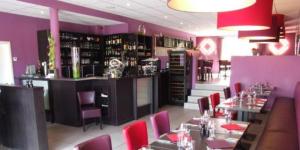 un restaurant avec des murs violets, des tables et des chaises rouges dans l'établissement Well'in Hotel, à Wellin