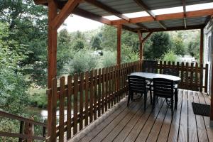 una terraza de madera con mesa y sillas. en Chalet Arran en Enscherange