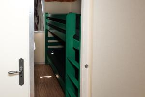ein grünes Etagenbett in einem kleinen Zimmer in der Unterkunft Chalet Arran in Enscherange