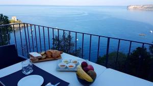 un tavolo con cibo sopra con vista sull'acqua di Villa Crawford a San Nicola Arcella