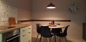 a kitchen with a small table and a clock on the wall at Ferienwohnung Lilly in Ostseebad Karlshagen