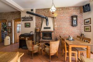 comedor con pared de ladrillo y chimenea en Villa Hubertus, en Srebrna Góra