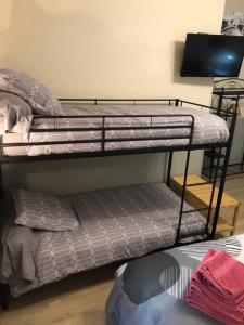 two bunk beds in a room with a tv at Hotel des Remparts in Villeneuve-sur-Lot