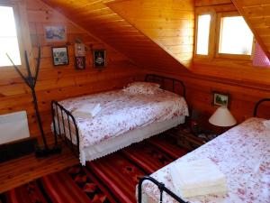 a bedroom with two beds in a wooden cabin at Vytina log house in Vytina +15 photos