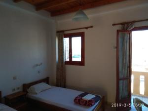 ein kleines Schlafzimmer mit einem Bett und einem Fenster in der Unterkunft karave in Gavdos