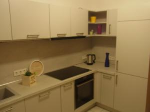 a kitchen with white cabinets and a white refrigerator at City Wohnung Mozart in Saarbrücken