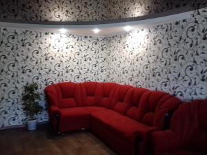 a red couch in a room with black and white wallpaper at вулиця Електрометалургів in Nikopol