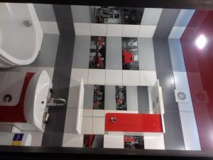 La salle de bains est pourvue d'un mur en carrelage rouge et blanc. dans l'établissement вулиця Електрометалургів, à Nikopol
