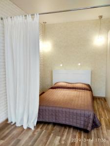 1 dormitorio con cama y cortina blanca en Simply the best, en Odessa