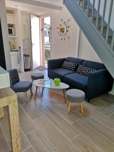 - un salon avec un canapé bleu et une table dans l'établissement Appartement Sainte-Maxime, plage de la Nartelle, à Sainte-Maxime