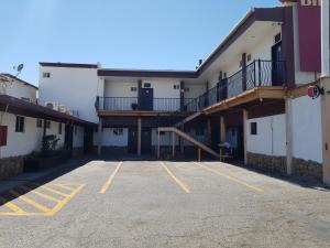 an empty parking lot in front of a building at Hotel Don Quijote in Mexicali