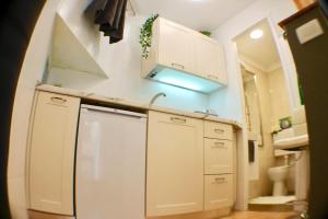 a small kitchen with white cabinets and a sink at Amorino Apartman Studio in Opatija +57 photos
