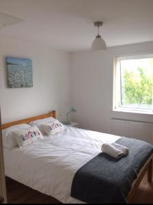 a bedroom with a large white bed with a window at 11 longstone house in Carbis Bay