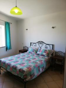 una camera da letto con un letto con una trapunta sopra di Rossio Sol Mar a Lagos Altre 41 foto
