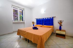 a bedroom with a bed with a blue head board at De finibus terrae in Leuca