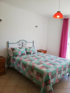 a bedroom with a bed with a green quilt at Rossio Sol Mar in Lagos