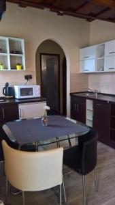 a kitchen with a table with chairs and a microwave at 264 lépés Vendégház in Sárvár