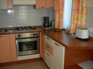 a kitchen with a stove and a counter top at Sunshine Beach House in Szántód