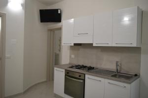 a kitchen with white cabinets and a sink and a stove at La Dimora di Maja in Pescara