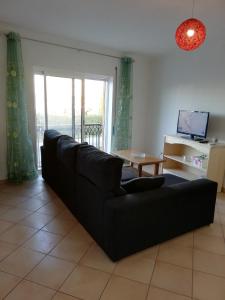 a living room with a black couch and a table at Rossio Sol Mar in Lagos