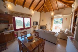 eine Küche und ein Wohnzimmer mit einem Tisch und Stühlen in der Unterkunft Irene's Comfort Villa in Nea Epidavros