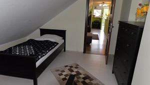 a bedroom with a bed and a dresser and a hallway at Apartament u Robsona in Wilkasy +2 photos
