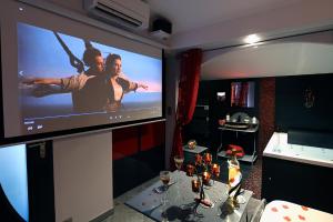 a room with a large screen with a table with wine glasses at Une Parenthese pour Deux in Plan-dʼOrgon