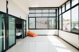 an empty room with windows and an orange pillow at The Aqua Kohphangan in Haad Rin