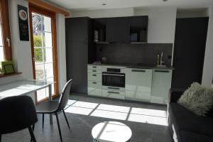 a kitchen with a couch and a table in a room at Art Oase - Lenzspitze in Saas-Grund